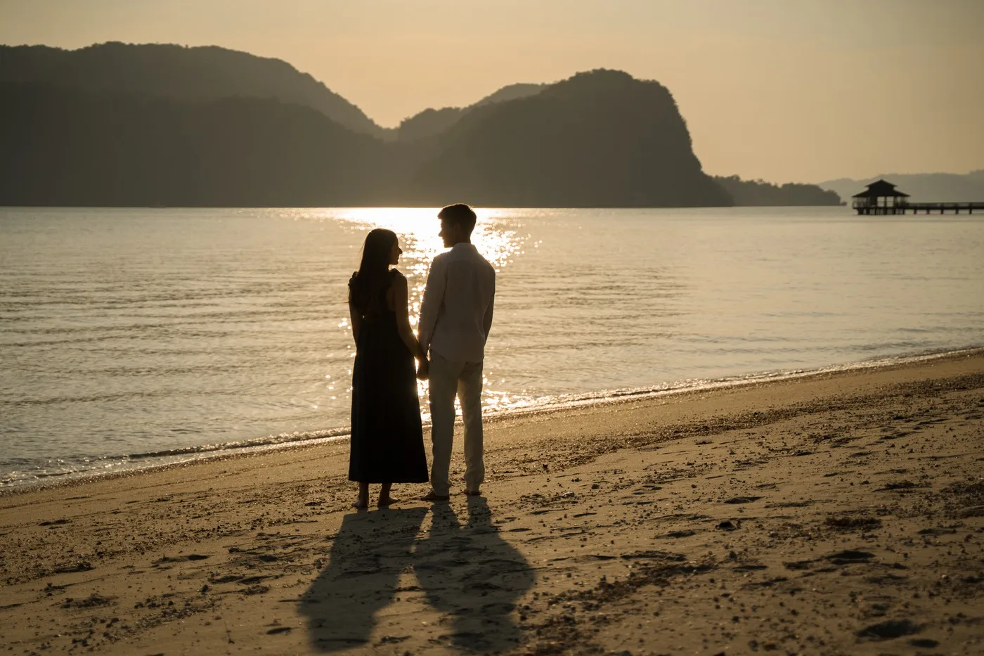 Alisha and Kunal together on the beach in the golden evening light